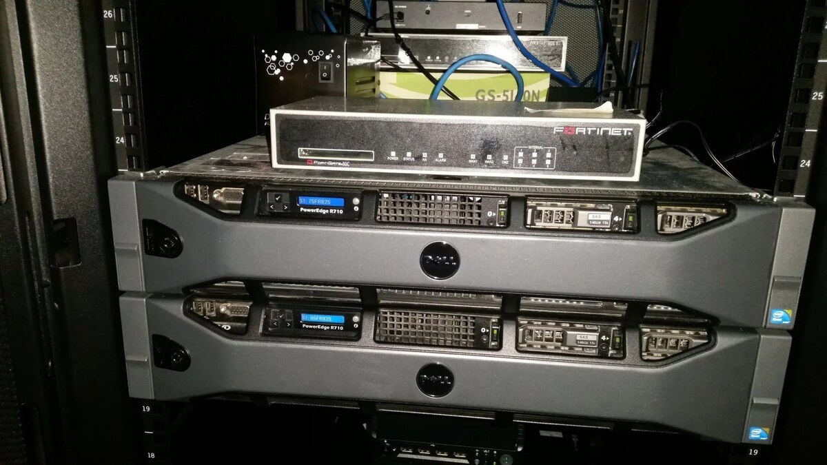 Fortinet firewall and Dell PowerEdge servers in a production rack, illustrating the infrastructure layers behind 24/7 technology operations.
